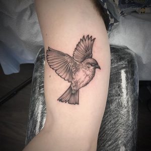 "Small bird bicep tattoo"